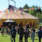Sous le chapiteau de L'Hurluberlu, l'école de cirque qui fait grandir les enfants Enfants et parents entrent sous le chapiteau du cirque pour voir les représentations des artistes au festival de Chap’erlipopette