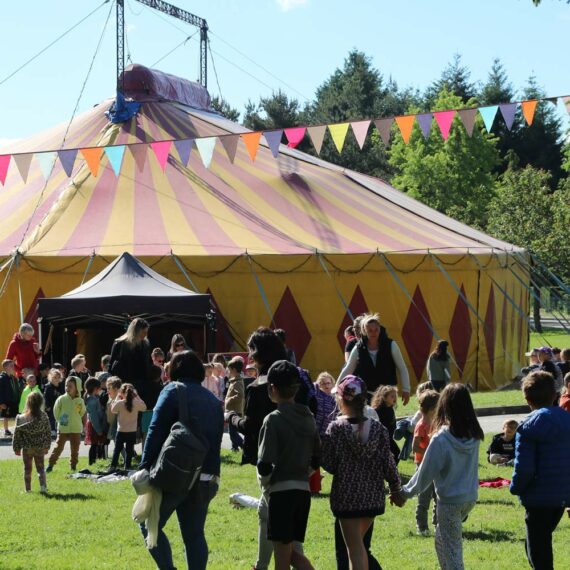 Enfants et parents entrent sous le chapiteau du cirque pour voir les représentations des artistes au festival de Chap’erlipopette